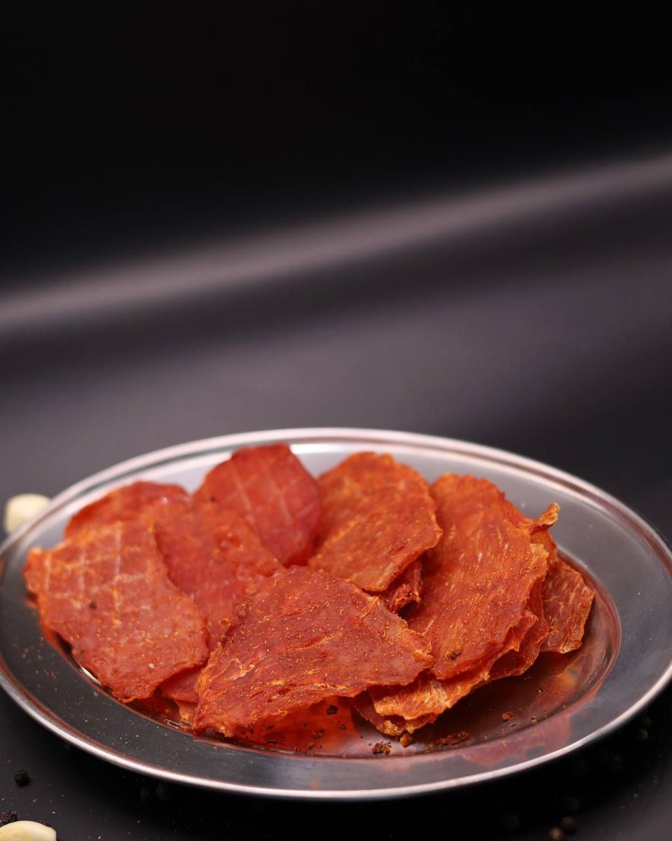 Курячі джерки AXE Jerky на тарілці з часником і спеціями
