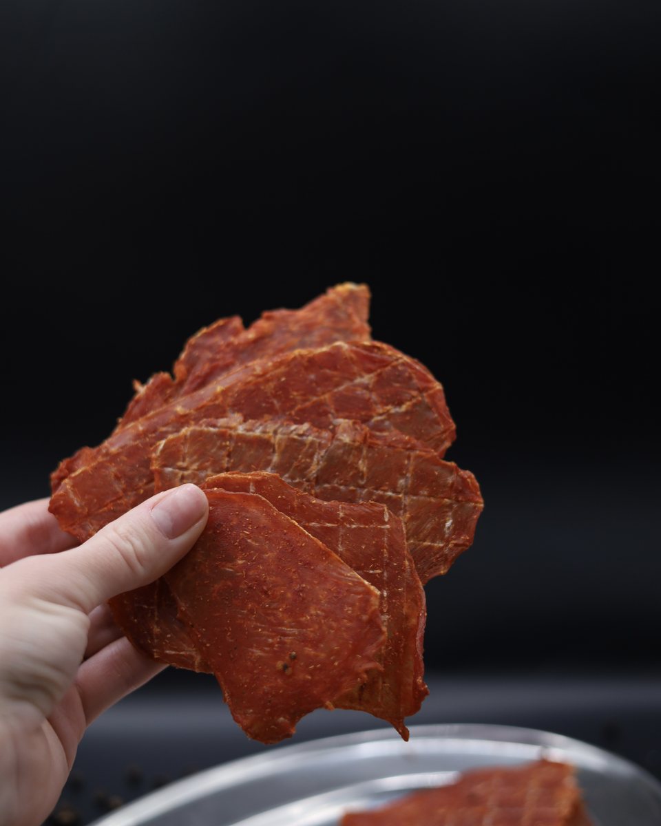 Скибочка курячих джерків AXE Jerky в руці