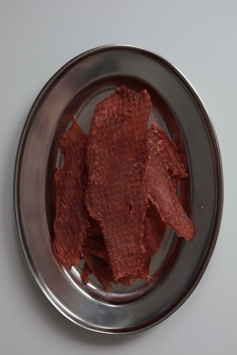 Скибочки курячих джерків AXE Jerky на металевій тарілці