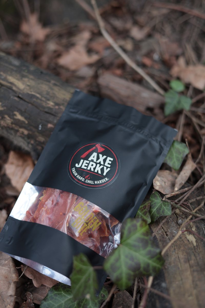 Пачка курячих джерків AXE Jerky у лісі серед листя