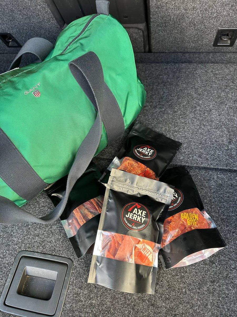 Курячі джерки AXE Jerky у багажнику поруч із дорожньою сумкою